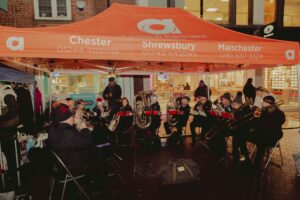 A selection of images from Carols in the City 2024 featuring a brass band, rock choir and the crowds.